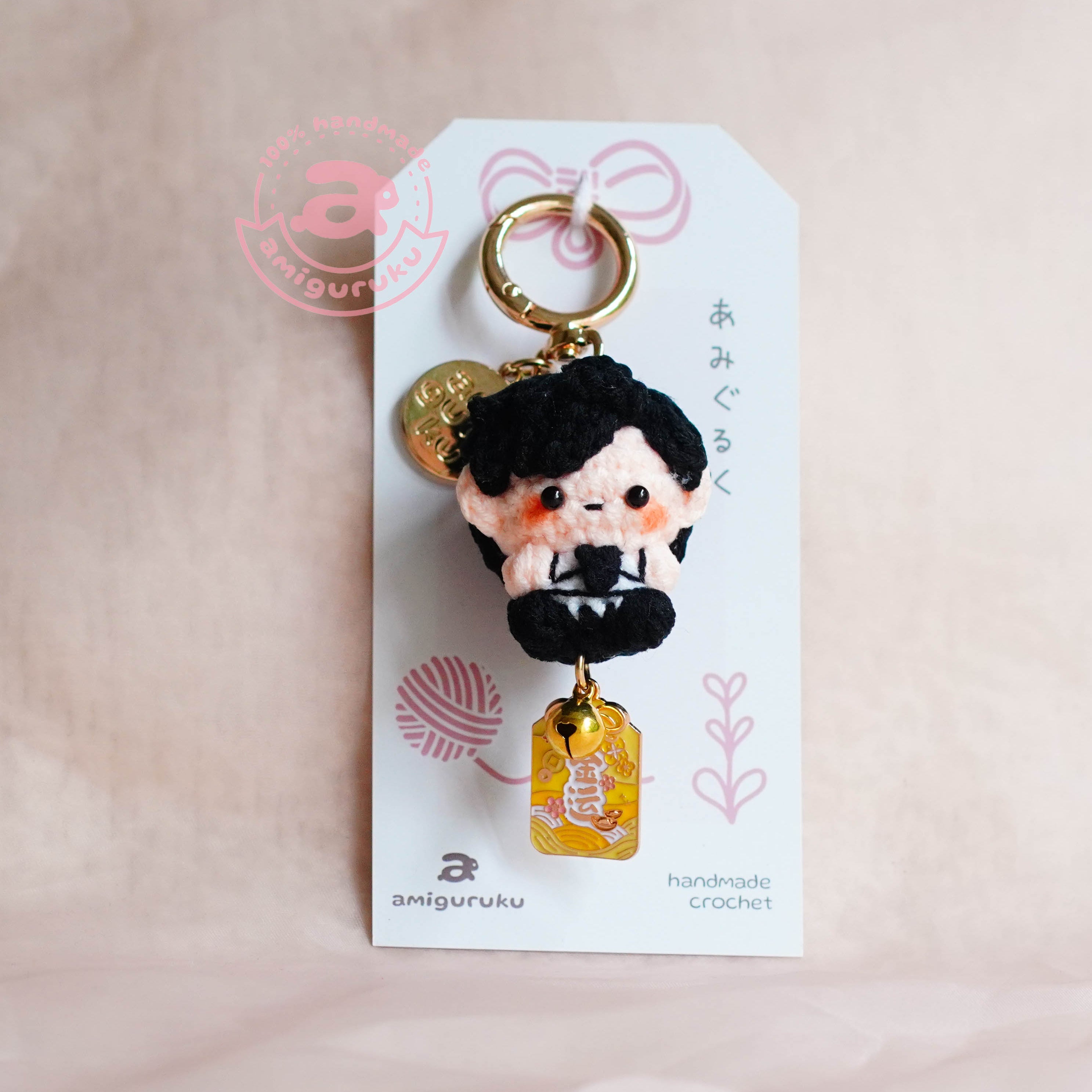 Keychain with a character design on a white card against a pink background
