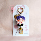 Keychain with a character on a white tag against a beige background