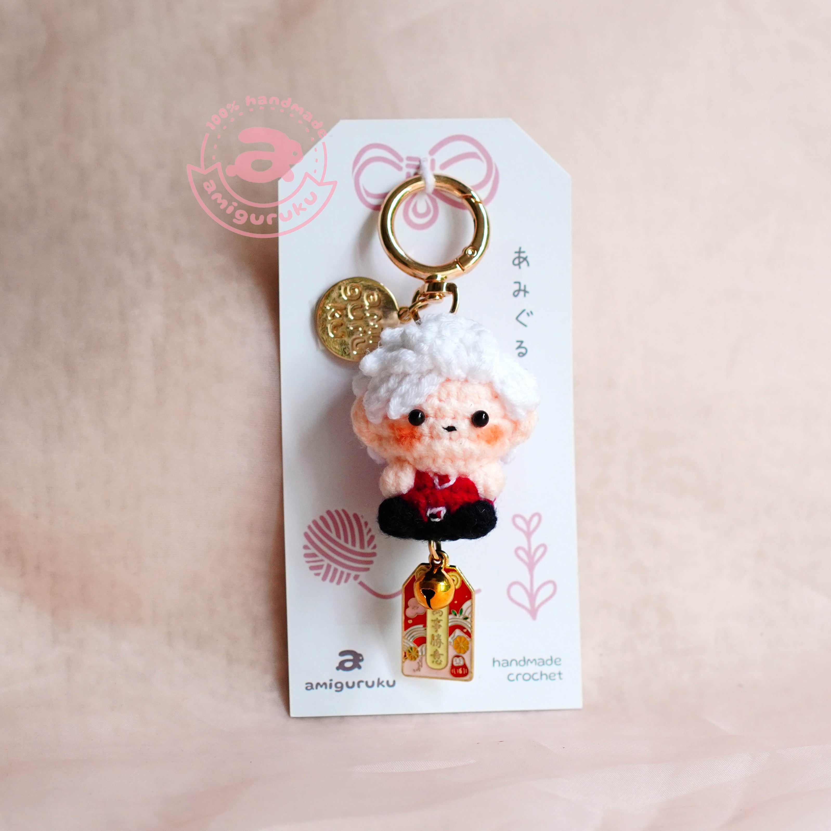 Keychain with character design on a white card against a beige background